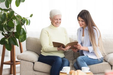 Üst düzey kadın ve kızı albümündeki fotoğrafları bakarak