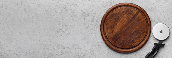 Cutting board and steel pizza cutter, top view — Stock Photo, Image