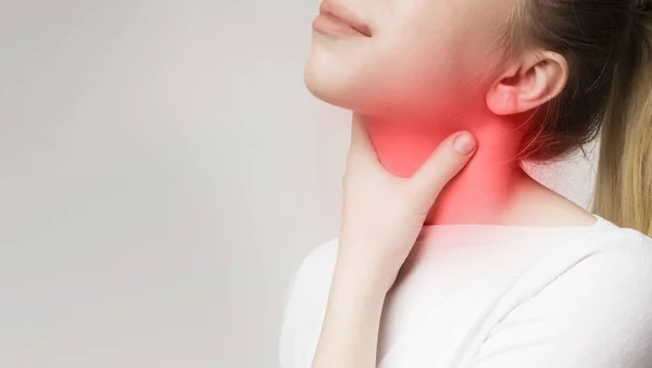 Mujer que sufre de dolor de garganta, tocándose el cuello —  Fotos de Stock