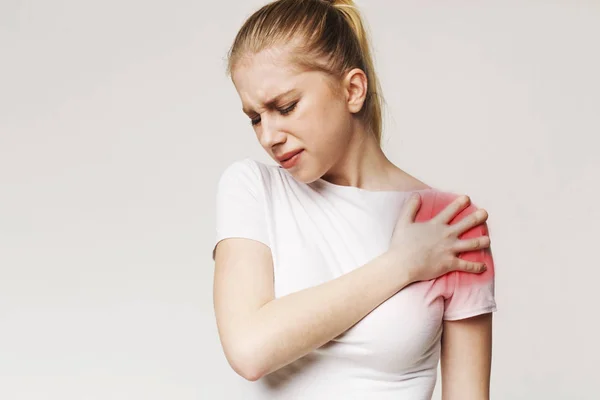 Jonge vrouw die lijden aan pijn in schouder — Stockfoto