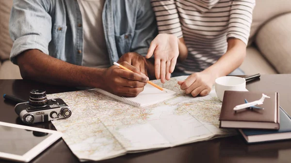 Couple planning vacation, making notes in diary