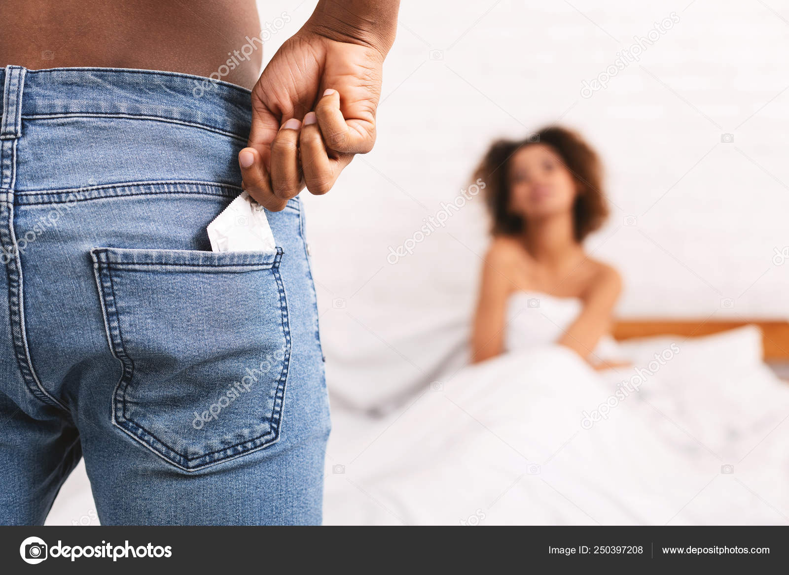 Man taking condom from jeans, woman waiting in bed Stock Photo by ©Milkos 250397208 picture