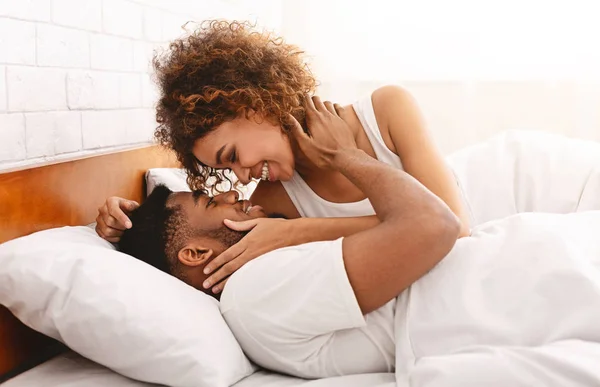 Afro-Amerikaanse meisje haar geliefde te kussen in bed — Stockfoto
