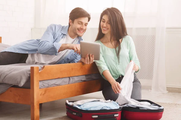 Feliz pareja planeando viaje de vacaciones en la tableta — Foto de Stock