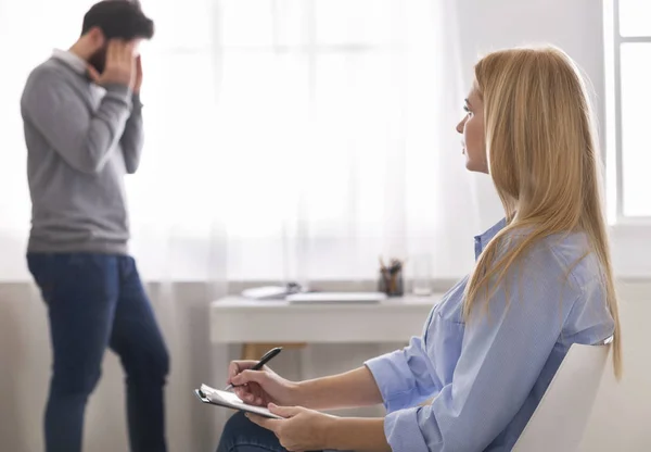 Depressed man emotionally speaking at psychotherapist session — Stock Photo, Image