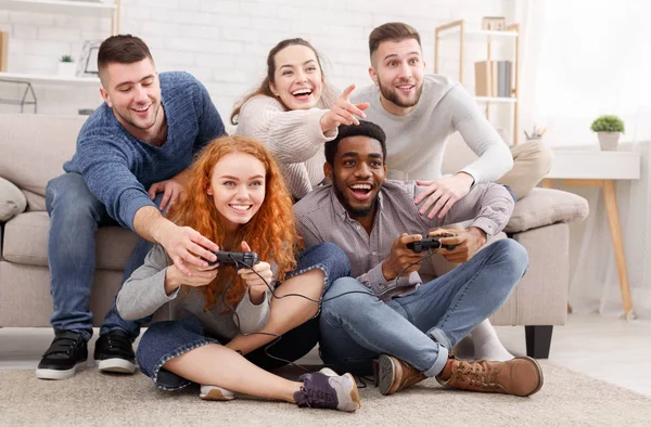 Amigos adultos jugando videojuegos, sentados en el suelo en casa — Foto de Stock