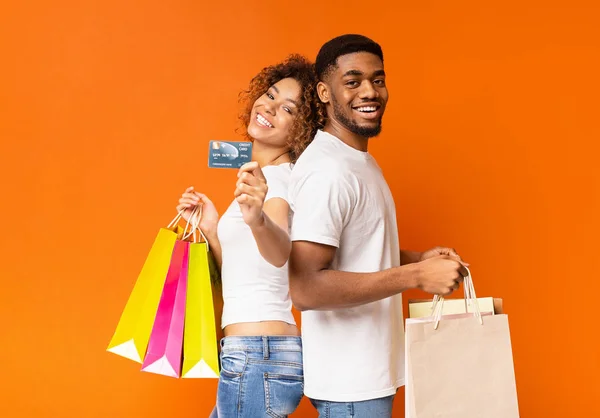 Joven pareja negra con bolsas de compras y tarjeta de crédito — Foto de Stock