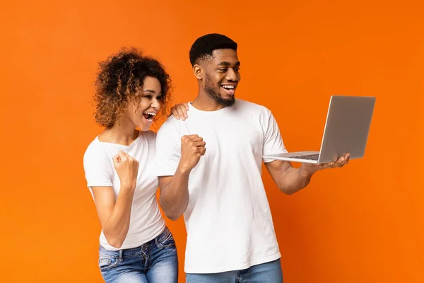 Emocionado casal negro comemorando vitória com laptop — Fotografia de Stock