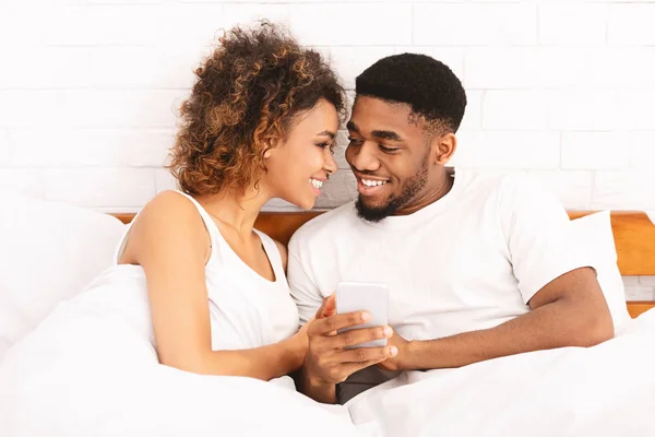 Älskande svart par avkopplande i sängen hemma — Stockfoto