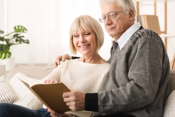 Family photoalbum. Senior couple looking at photos — Stock Photo, Image