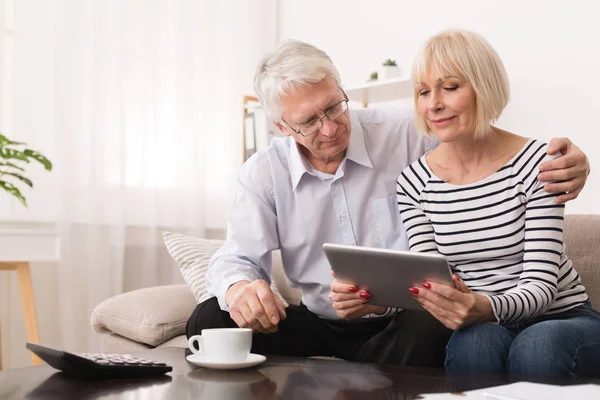 Seniorenpaar nutzt digitales Tablet im Wohnzimmer — Stockfoto