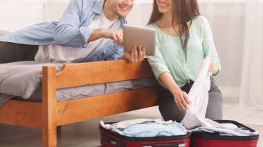 Çift balayı için hazırlanıyor, tablet kullanma ve bavul paketleme
