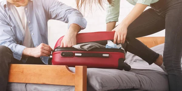 スーツケースをパッキングします。小型スーツケースを閉じようとしているカップル — ストック写真