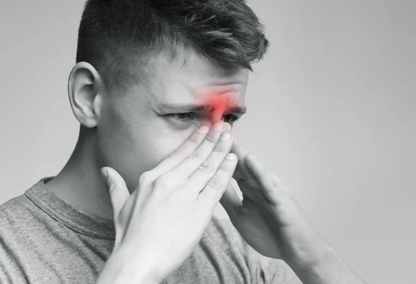 Triste hombre sosteniendo su nariz porque el dolor sinusal — Foto de Stock