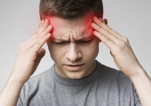 Hombre sufriendo de dolor de cabeza, tocando sus sienes — Foto de Stock