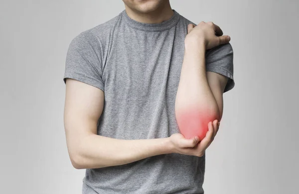 Cropped young man suffering from painful elbow — Stock Photo, Image