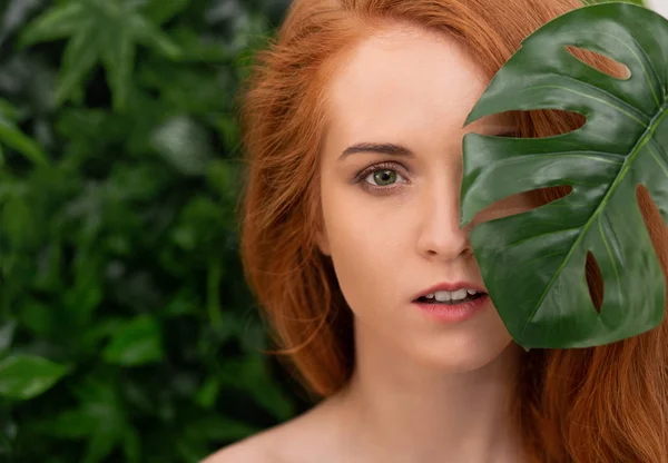 Mulher ruiva bonita com pele perfeita em folhas tropicais — Fotografia de Stock