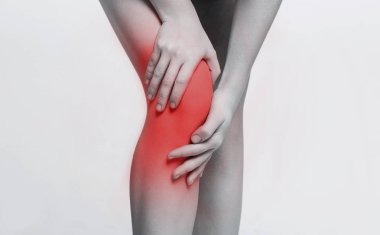 Genç kadın onun ağrılı diz closeup Masaj