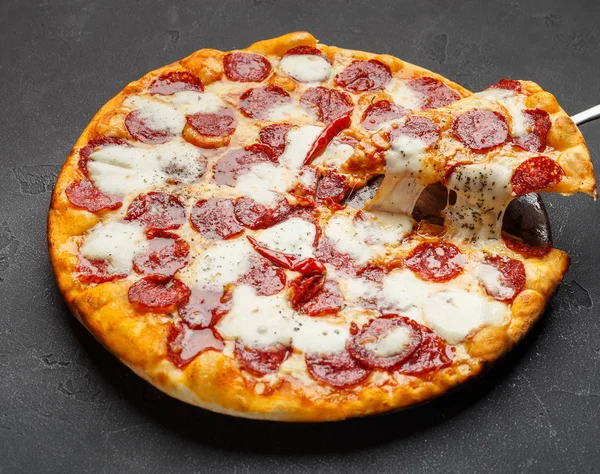 Heiße Pizza mit schmelzendem Käse auf dem Tisch — Stockfoto