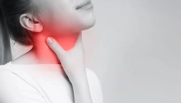 Mujer que sufre de dolor de garganta, tocándose el cuello —  Fotos de Stock