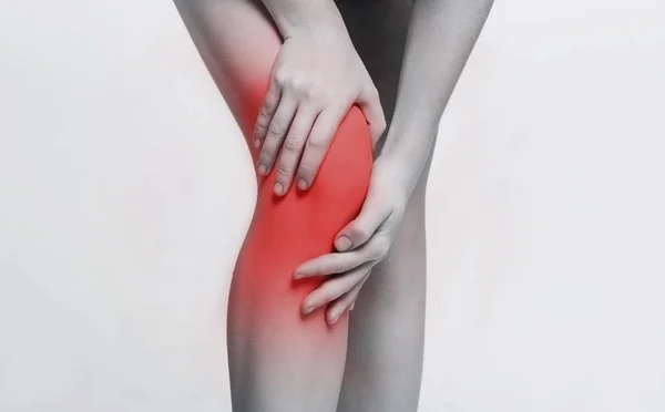 Mujer joven masajeando su doloroso primer plano de rodilla — Foto de Stock