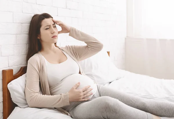 Mujer embarazada joven que sufre de dolor de cabeza o migraña — Foto de Stock