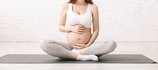 Mulher grávida meditando em posição de lótus em casa — Fotografia de Stock