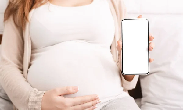 妊娠中の女性が空表示と携帯電話を表示 — ストック写真