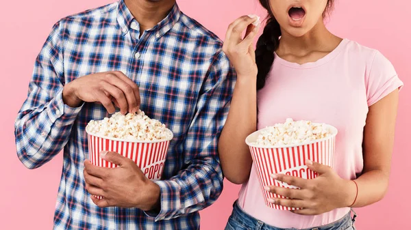 Pareja comiendo palomitas de maíz, viendo películas, fondo rosa —  Fotos de Stock