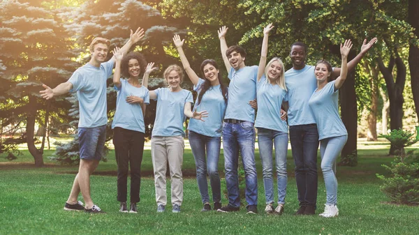 Groep van jonge vrijwilligers omarmen in park — Stockfoto