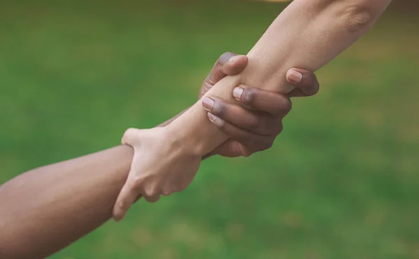 Amigos multiétnicos ayudando a la mano al aire libre, espacio de copia — Foto de Stock