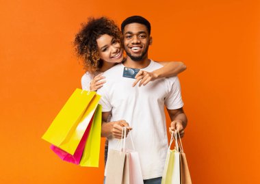 Genç çift alışveriş torbaları ve kredi kartı ile siyah