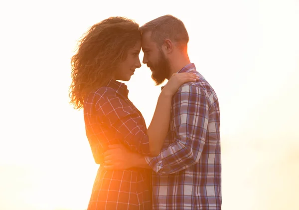 Perfil de ligação casal sereno uns com os outros contra o pôr do sol — Fotografia de Stock