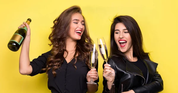 Duas meninas bonitas em jaquetas pretas se divertindo com champanhe — Fotografia de Stock