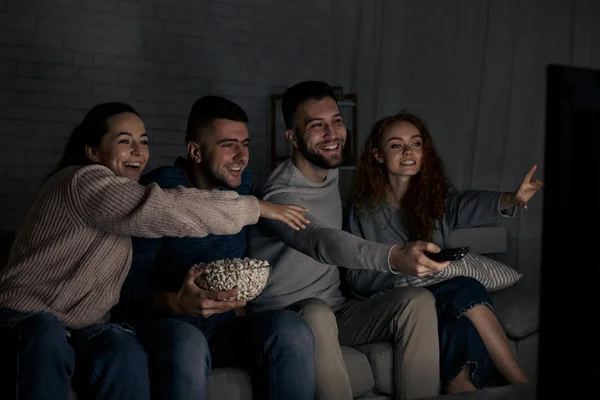 Happy friends watching TV and switching channels — Stock Photo, Image