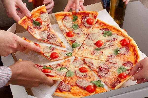 Freunde holen Pizza-Scheiben aus Pappschachtel — Stockfoto