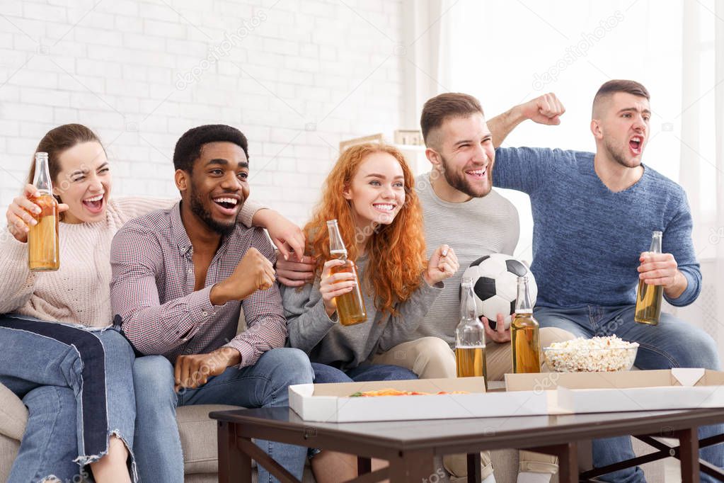 Excited football fans watching soccer on tv