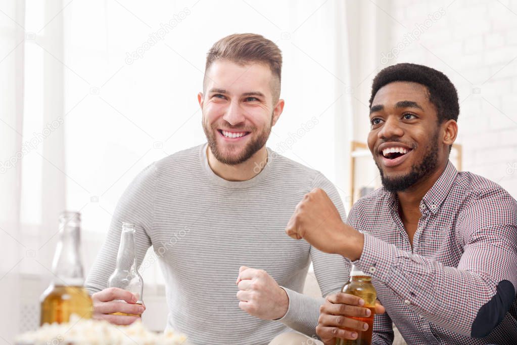 Guys drinking beer and cheering for football