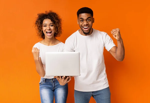Eccitato coppia nera celebrando vincere con il computer portatile — Foto Stock