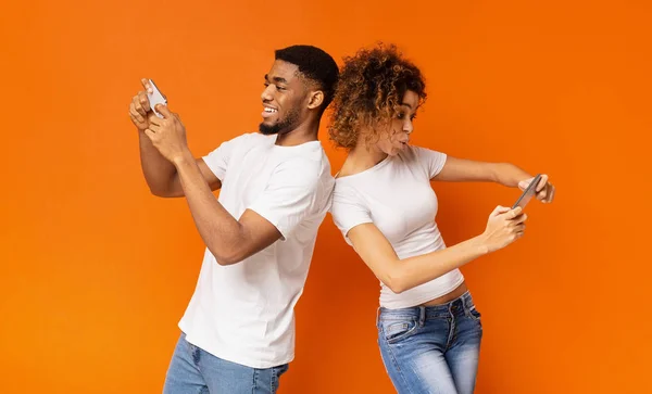 Jovem e mulher excitados brincando juntos em smartphones — Fotografia de Stock