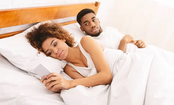 Woman chatting with lover on cellphone in bed — Stock Photo, Image