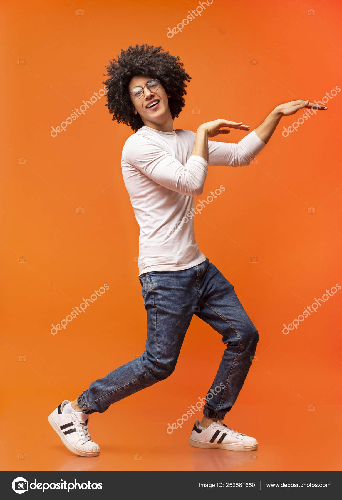 Funny black guy dancing in egypt style on orange background Stock Photo