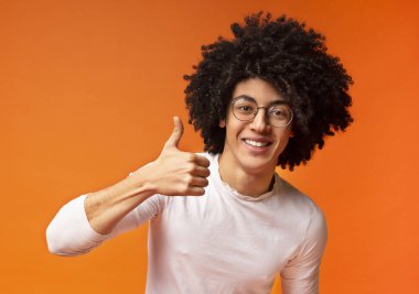 Neşeli Afrikalı-Amerikan kıvırcık adam gösteren başparmak yukarı