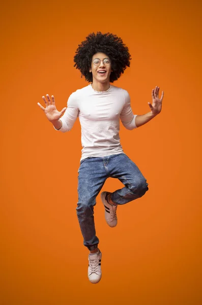 Веселый африканско-американский кудрявый парень, прыгающий в воздух — стоковое фото