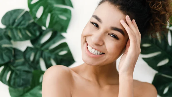 Mujer afroamericana con piel perfecta sobre hojas tropicales —  Fotos de Stock