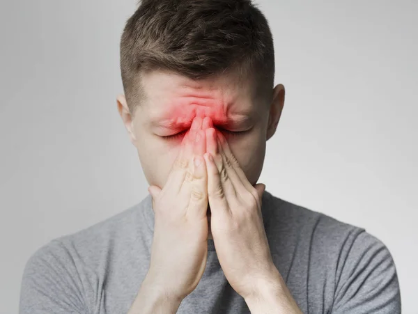 Trauriger Mann hält Nase wegen Nasennebenhöhlenschmerzen — Stockfoto