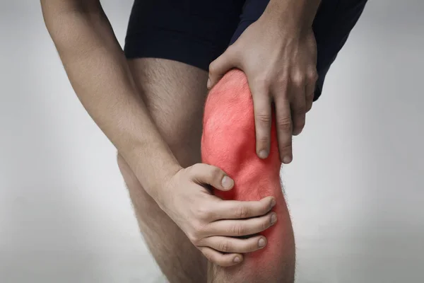Молода управління масаж її болюче коліно крупним планом — стокове фото