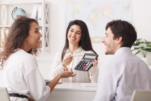 Travel agent showing tour value on calculator