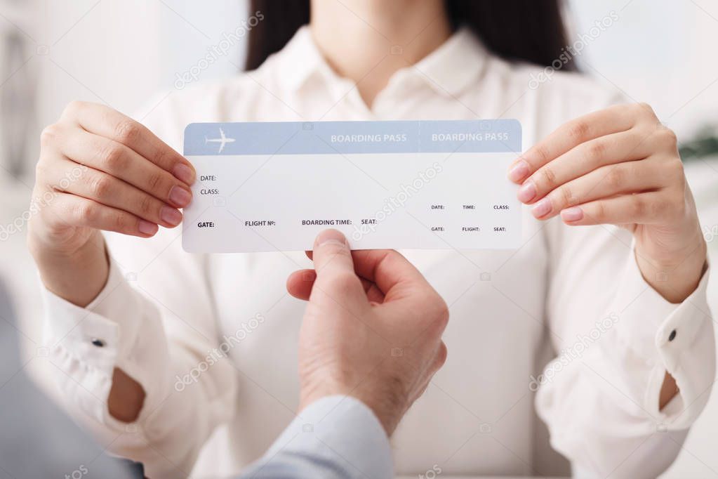 Travel agent showing flight ticket to customer