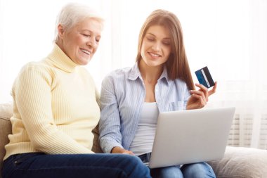 Üst düzey kadın ve kızı alışveriş online üstünde laptop